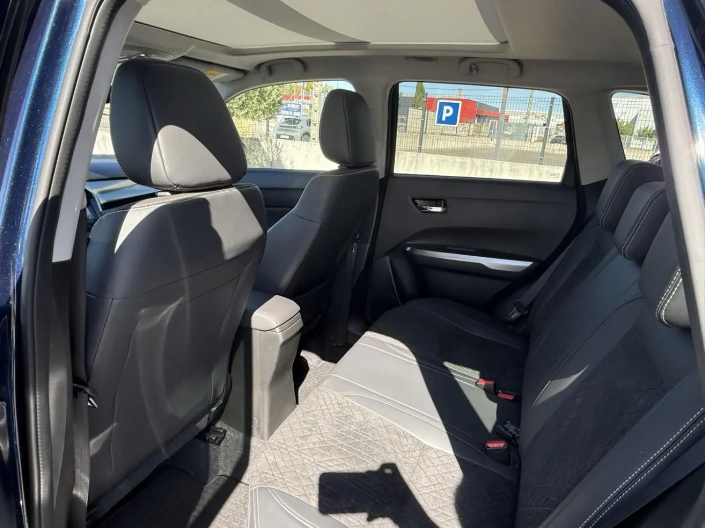 Intérieur arrière du Suzuki Vitara 2025 bleu foncé métal, vue côté gauche montrant les sièges en tissu et cuir noir.