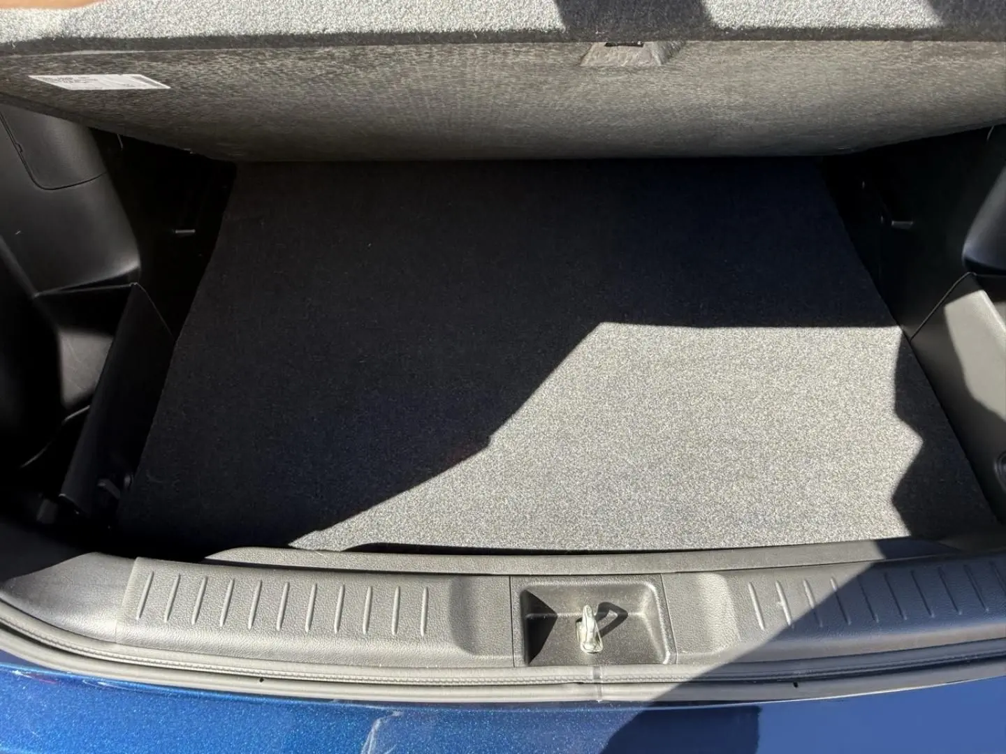 Vue plongeante sur le coffre vide du Suzuki Vitara 2025 bleu foncé métal, soulignant la finition intérieure propre et fonctionnelle.