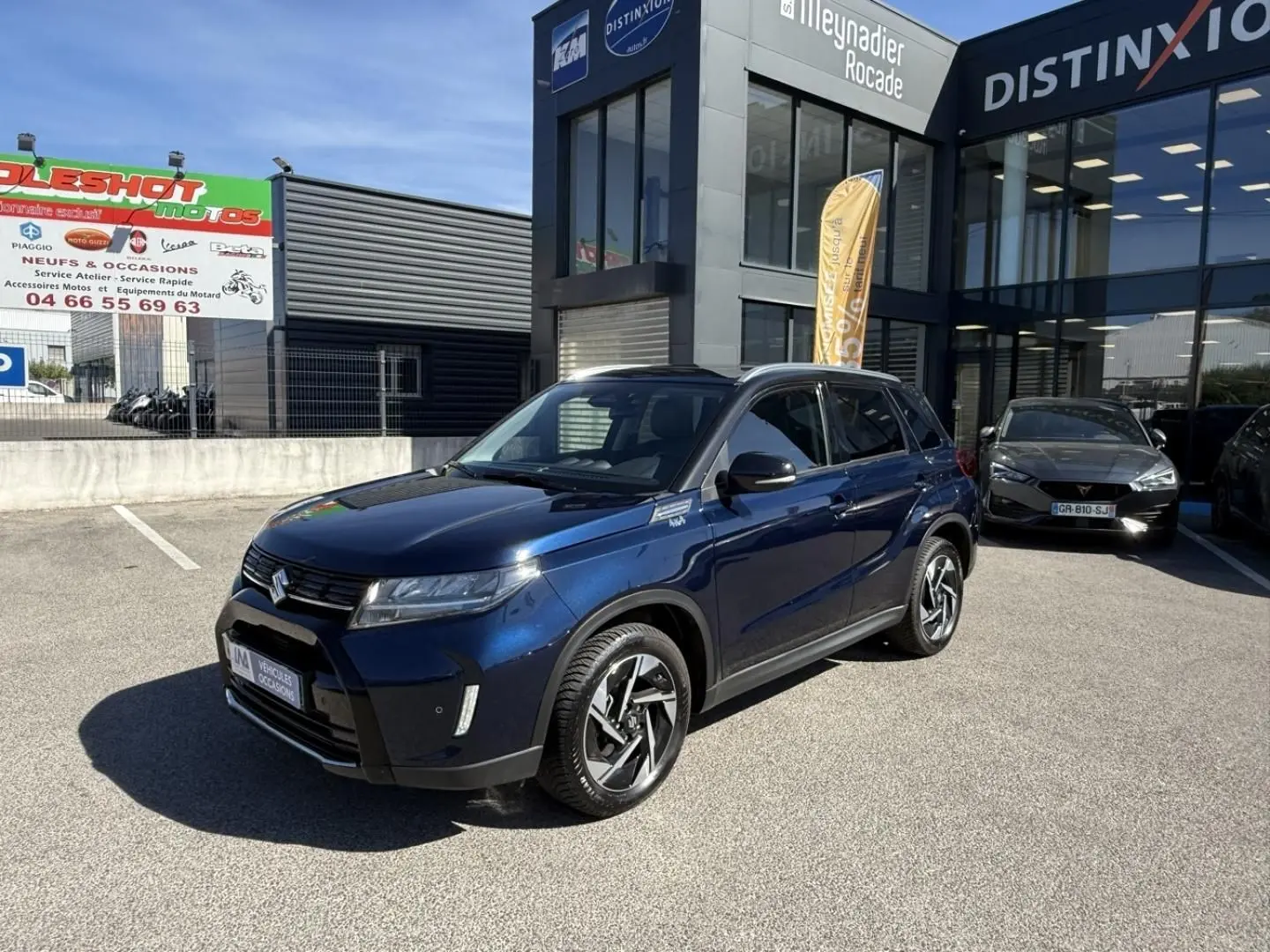 Suzuki Vitara 2025 bleu foncé métal en 3/4 avant droit, avec jantes alliage et détails noirs contrastants.