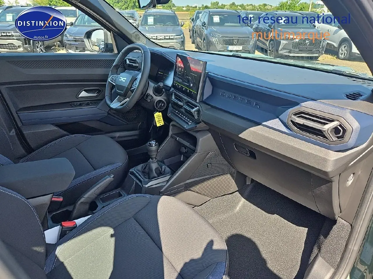 Intérieur noir du Dacia Duster 2025 vu côté conducteur, tableau de bord moderne avec écran tactile et volant multifonction.