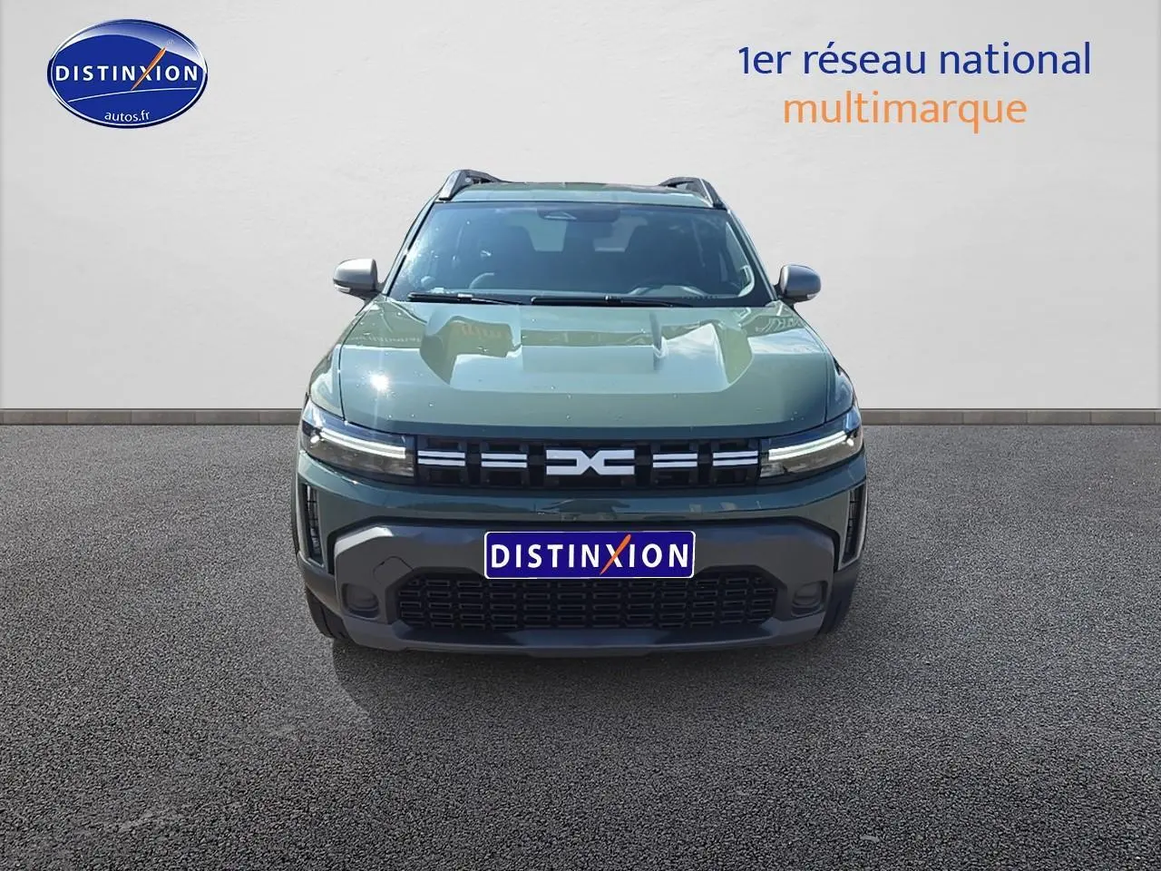 Vue avant d'un Dacia Duster 2025 vert kaki avec calandre moderne et barres de toit visibles.