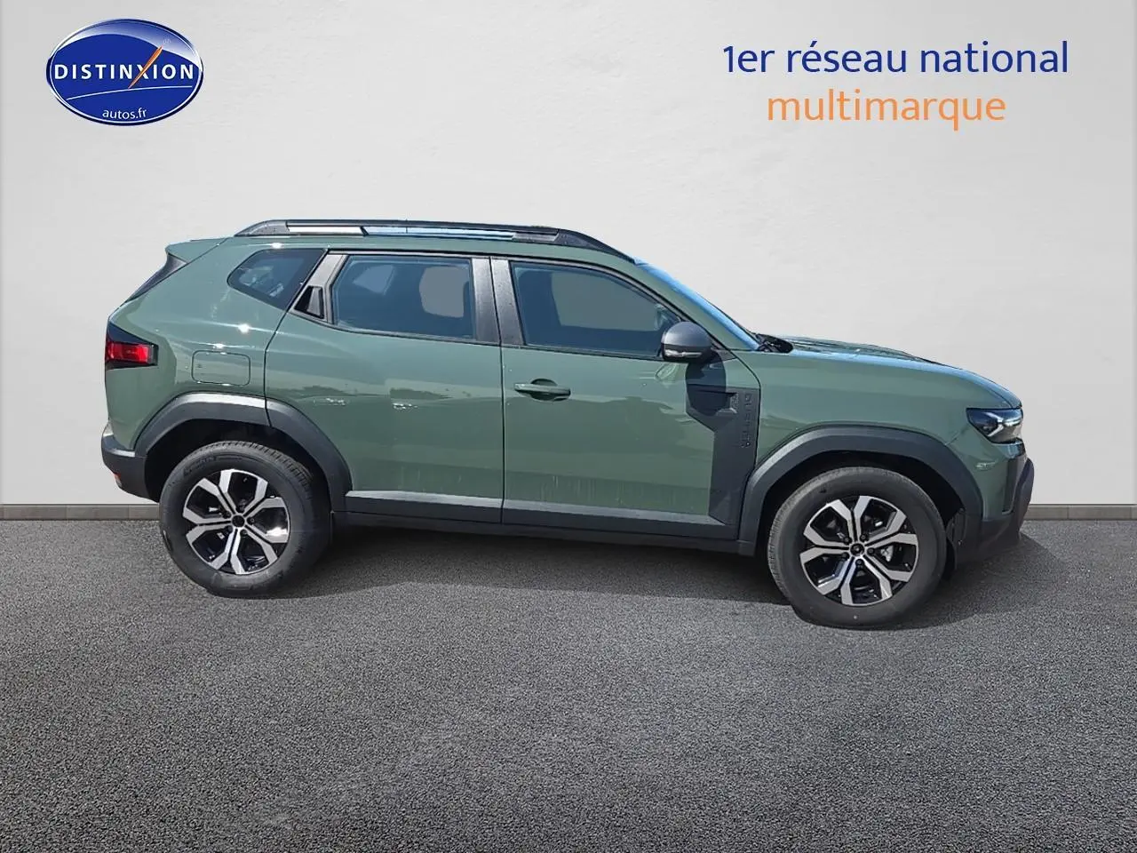 Profil droit du Dacia Duster 2025 vert kaki avec barres de toit et jantes alu distinctives.