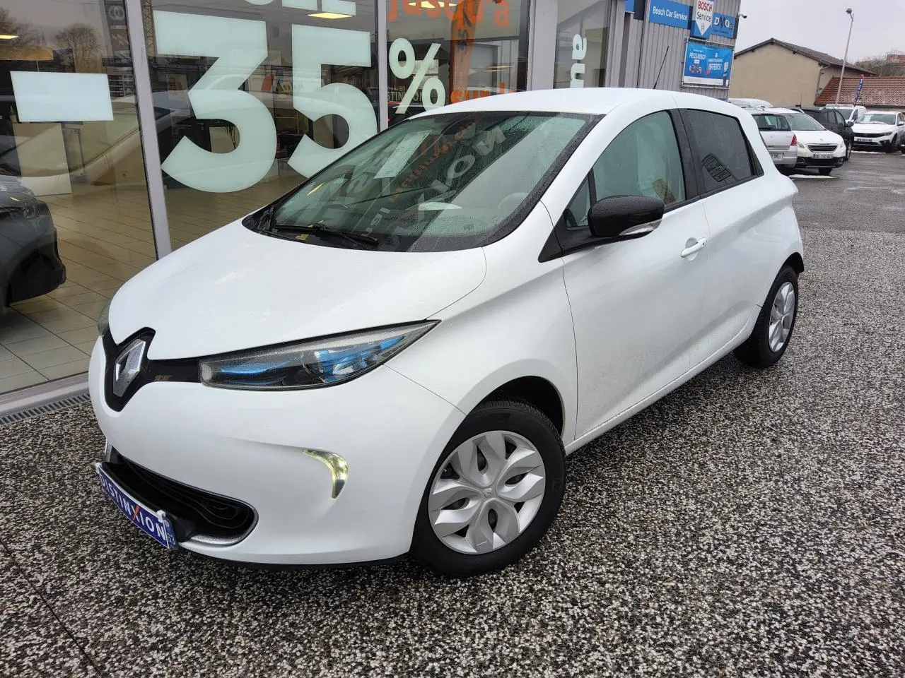 Renault ZOE électrique blanc vue 3/4 avant droit, avec phares LED et rétroviseurs noirs brillants.