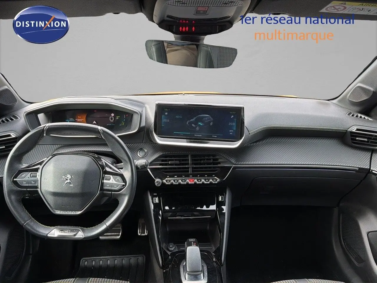 Vue intérieure frontale du tableau de bord et volant Peugeot 208 électrique GT Line avec finition carbone et écran tactile central.