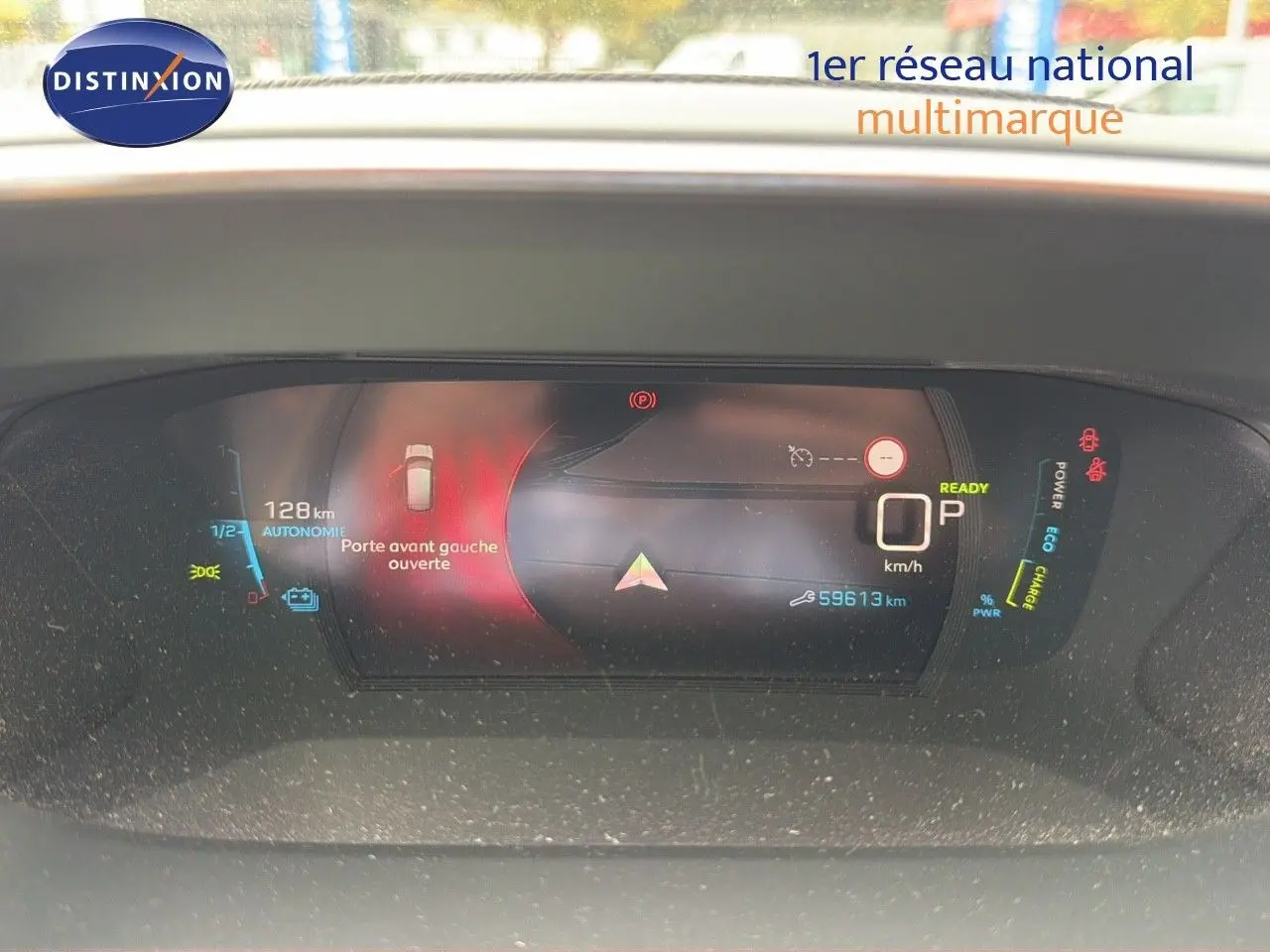 Tableau de bord numérique d'une Peugeot 208 électrique affichant porte avant gauche ouverte et autonomie restante.