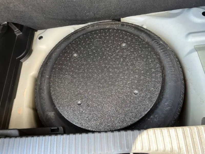 Gros plan sur la roue de secours dans le coffre d'une Citroën C3 Aircross 2018 couleur sable et noir