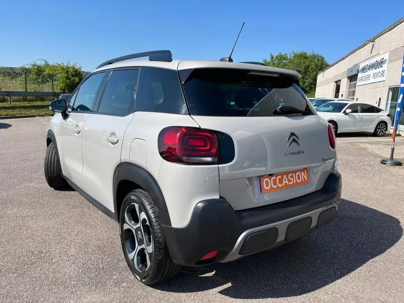 Vue 3/4 arrière droite d'une Citroën C3 Aircross sable avec toit noir et feux arrière distinctifs en relief