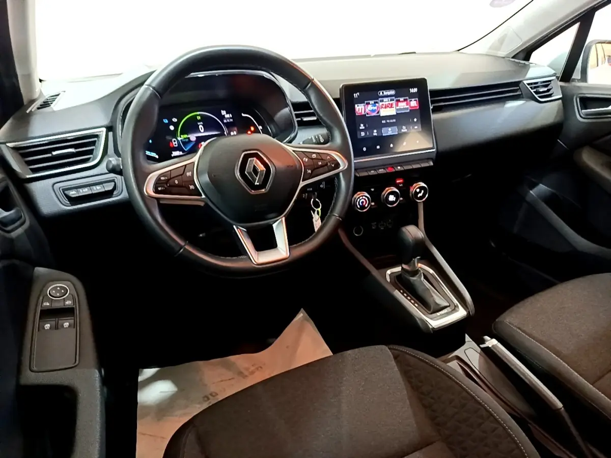 Intérieur noir de la Renault Clio Business E-TECH 140, vue du poste de conduite avec volant cuir et écran tactile central.