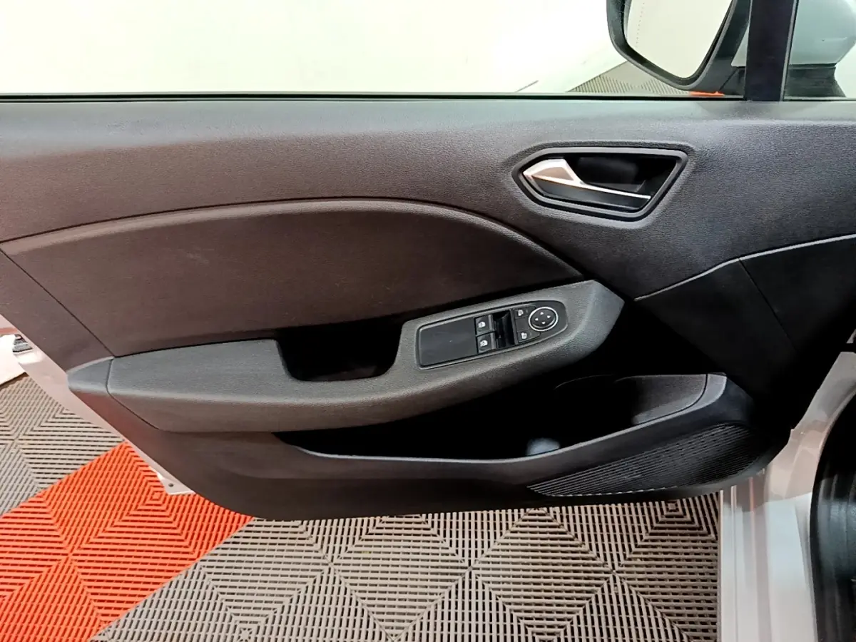 Vue intérieure côté gauche de la porte avant d'une Renault Clio Business E-TECH 140, avec commandes de vitres et rétroviseur.