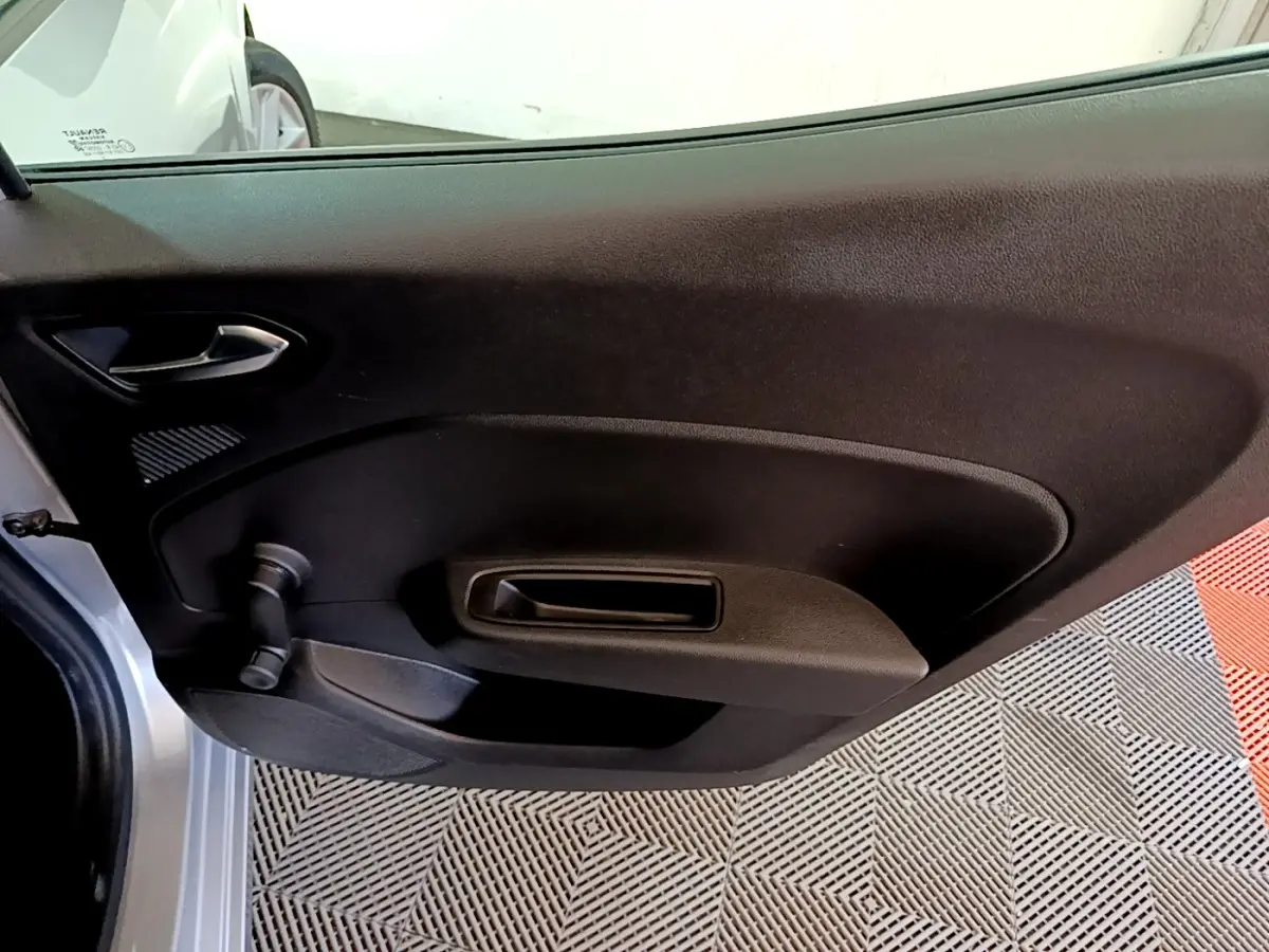 Vue intérieure côté gauche de la porte arrière d'une Renault Clio gris foncé avec poignée de fenêtre manuelle.