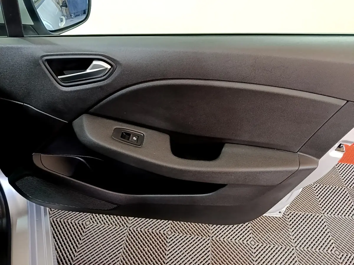 Vue intérieure côté gauche de la porte avant d'une Renault Clio Business E-TECH 140 gris foncé avec poignée et commande de vitre électrique.