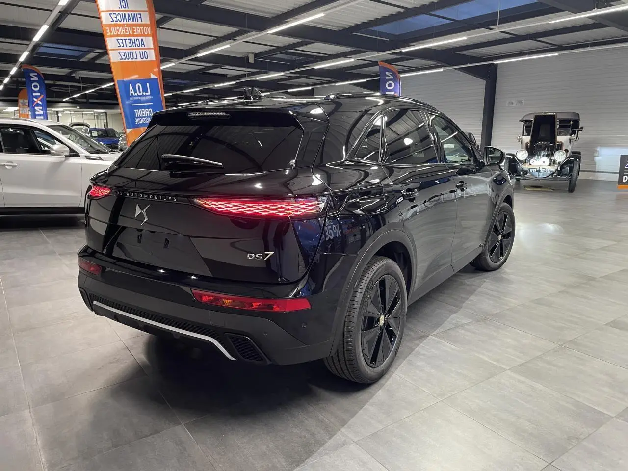 Vue 3/4 arrière droite du DS7 Crossback noir métallisé avec feux arrière LED 3D et jantes alliage 19 pouces.