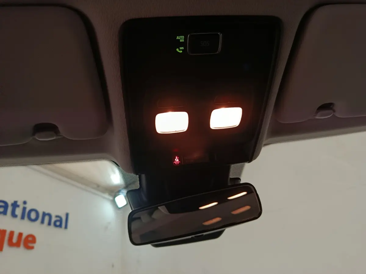 Vue intérieure du plafonnier et du rétroviseur intérieur d’une Renault Clio blanche, avec éclairage allumé.