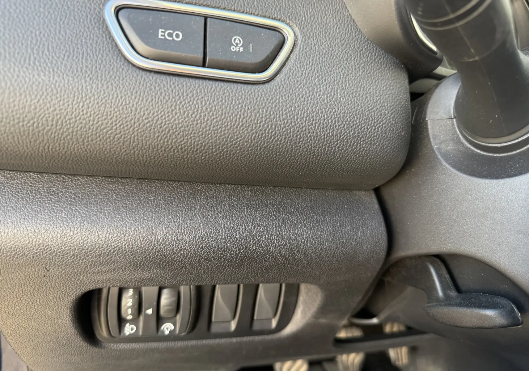 Détail intérieur côté gauche du tableau de bord du Renault Kadjar 1.5 DCI bleu, avec bouton ECO et commandes d’éclairage.