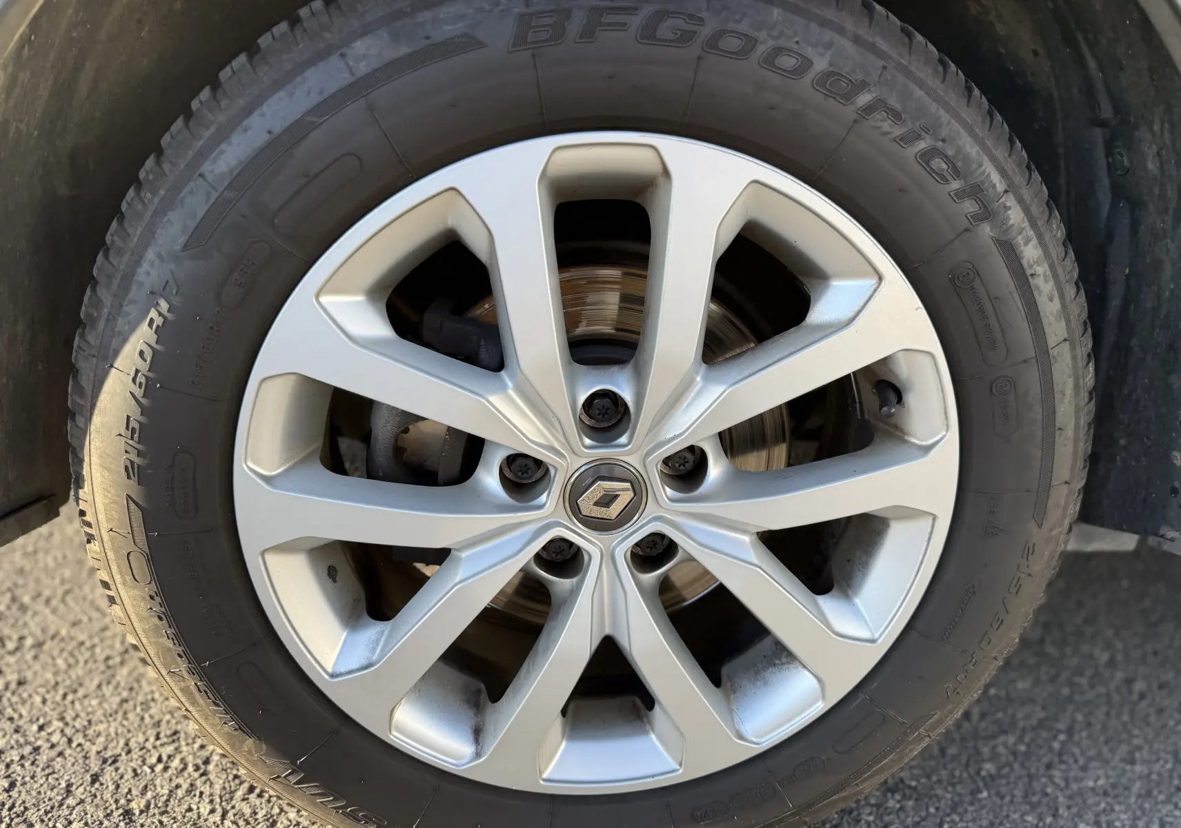Gros plan sur la jante alliage argentée d’un Renault Kadjar bleu, mettant en valeur le logo central et le pneu BFGoodrich.