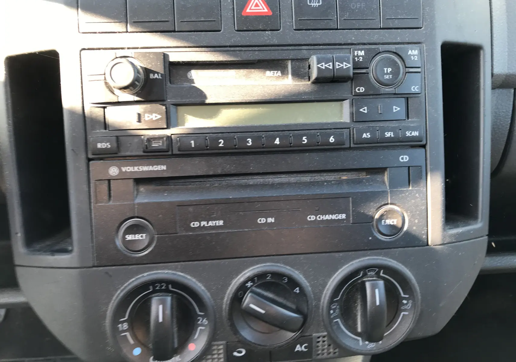Console centrale de la Volkswagen Polo Match 2004 montrant la radio CD et les commandes manuelles de climatisation.