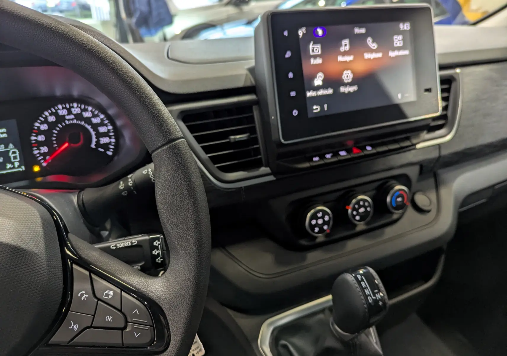 Intérieur du Renault Trafic Fourgon L2H1 2025, vue du tableau de bord avec écran tactile et commandes climatisation.
