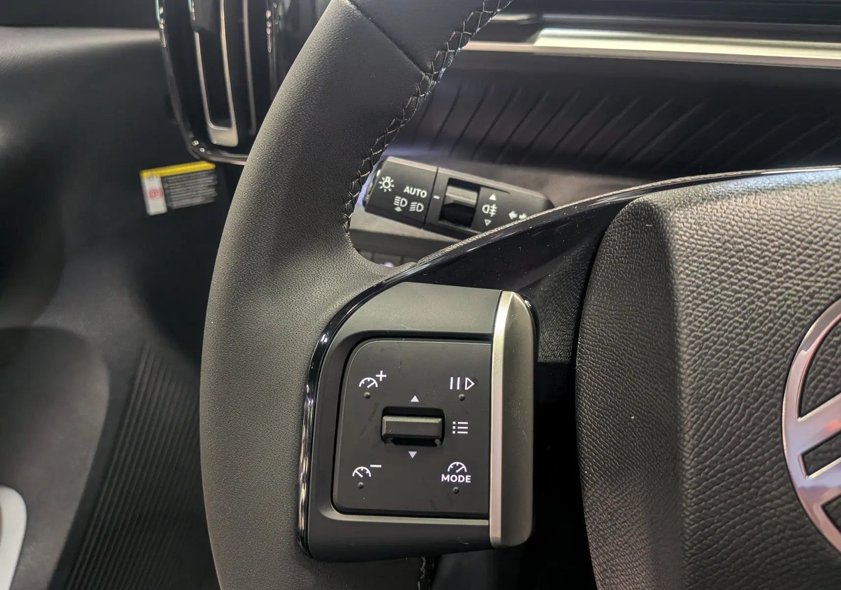 Gros plan sur le volant noir du Citroën C3 Aircross hybride 2025, montrant les commandes de régulateur de vitesse côté gauche.