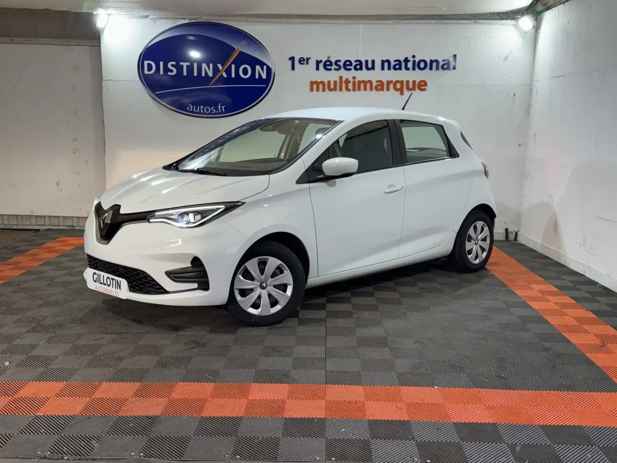 Renault ZOE Business blanc vue 3/4 avant droit en intérieur, avec phares LED et jantes acier.