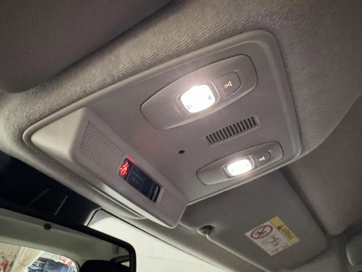 Plafonnier intérieur allumé vu de dessous dans une Renault ZOE Business blanc de 2020, avec éclairage de lecture et alerte ceinture.