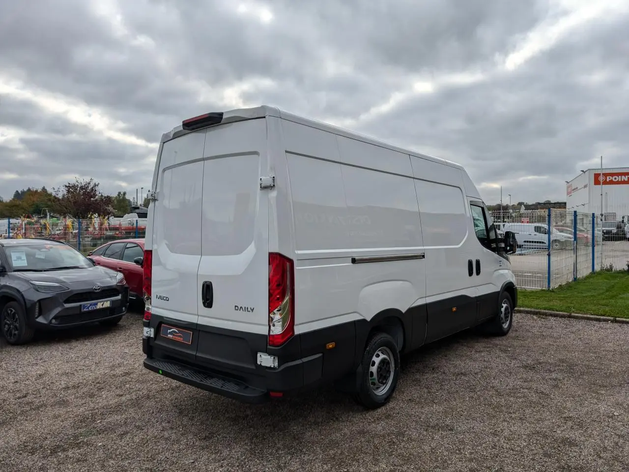 Vue 3/4 arrière droite d’un utilitaire Iveco Daily blanc avec portes arrière doubles et marchepied noir.