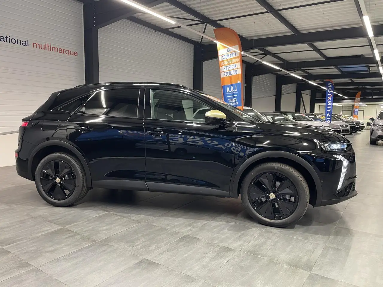 DS7 Crossback noir métallisé vu de profil côté gauche, avec jantes noires et coques de rétroviseur dorées satinées.
