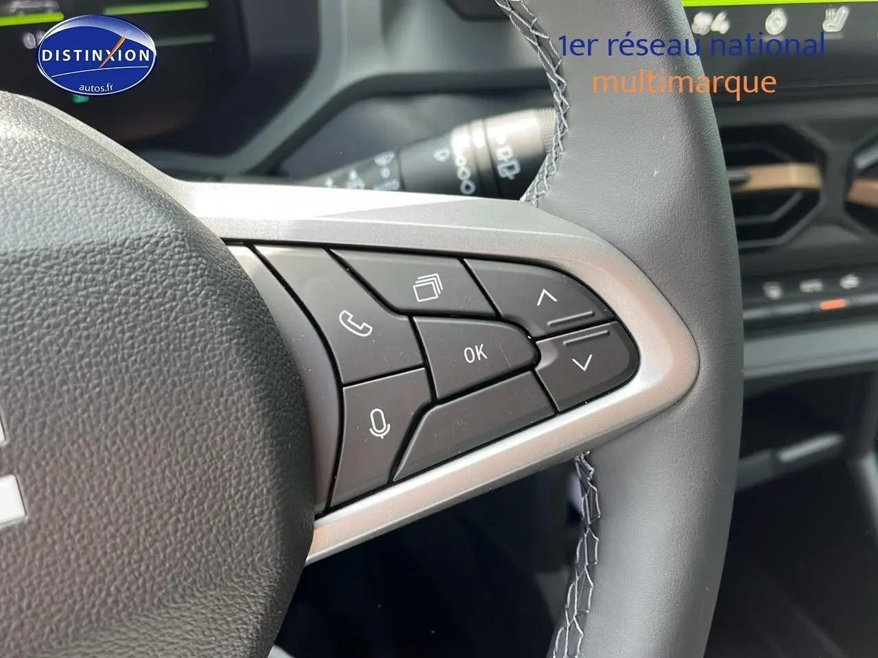 Gros plan sur les commandes multifonctions à droite du volant noir du Dacia Duster 2025, intérieur moderne et épuré.