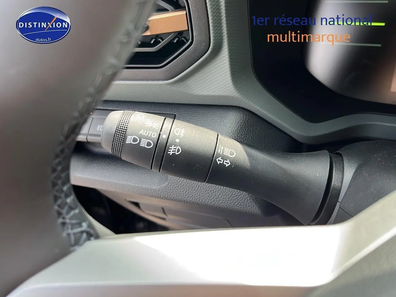 Gros plan sur la commande des phares et clignotants du Dacia Duster 2025 noir, vue depuis le volant côté gauche.