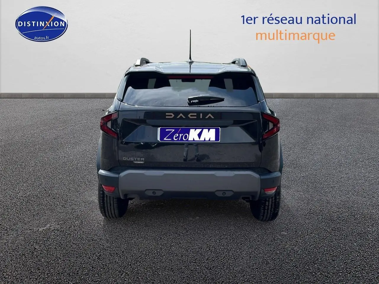 Vue arrière du Dacia Duster noir 2025 avec barres de toit et becquet, sur fond neutre gris.