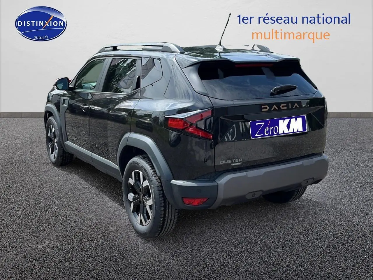 Vue 3/4 arrière droite du SUV noir DACIA DUSTER 2025 avec barres de toit et jantes alu distinctives.