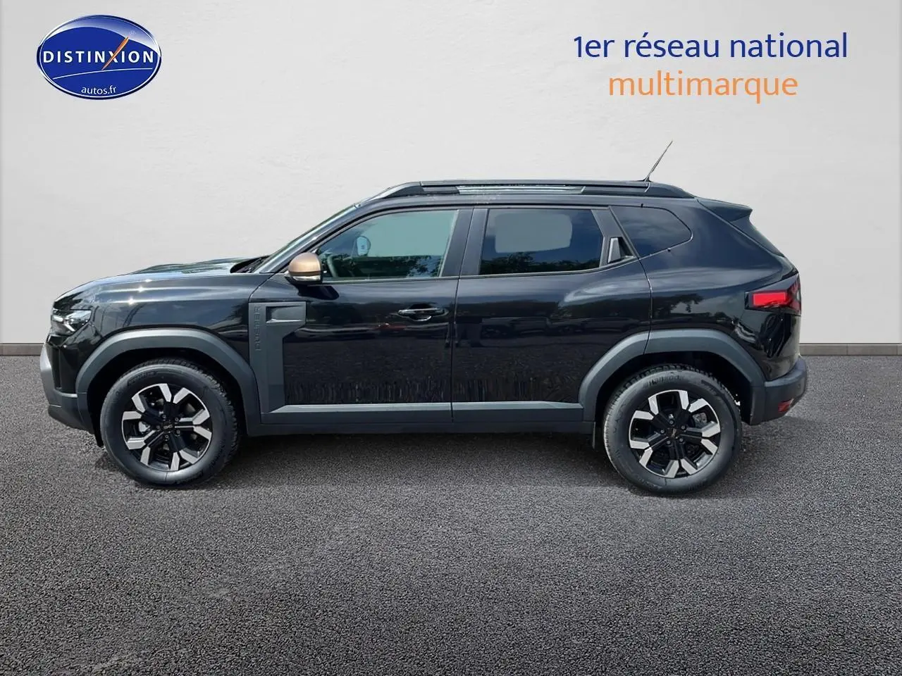 Profil côté gauche du Dacia Duster noir 2025 avec jantes alu et rétroviseurs couleur bronze.