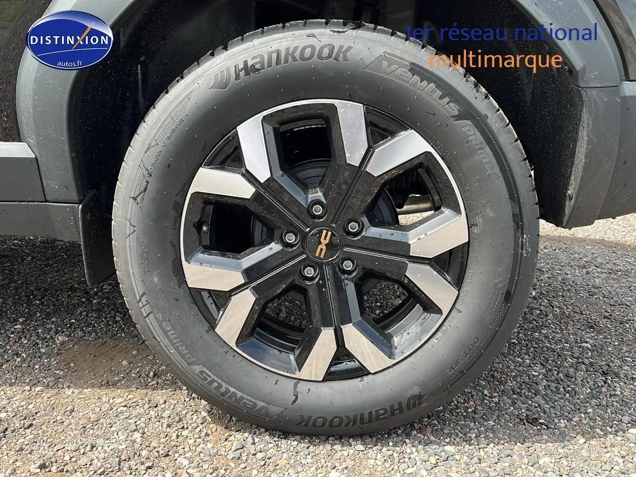 Gros plan sur la jante alu noire et argentée du côté gauche d'un Dacia Duster noir 2025.