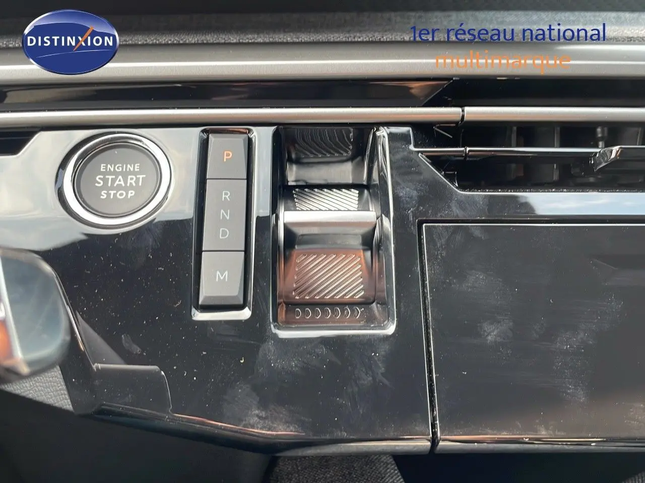 Gros plan sur la console centrale noire brillante du Peugeot 3008 Hybrid 2025 avec boutons de sélection de vitesse et démarrage moteur.