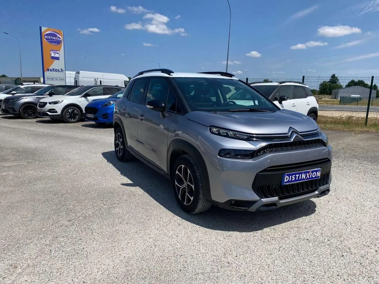 Citroën C3 Aircross gris Artense avec toit blanc, vue 3/4 avant droit sur parking ensoleillé.