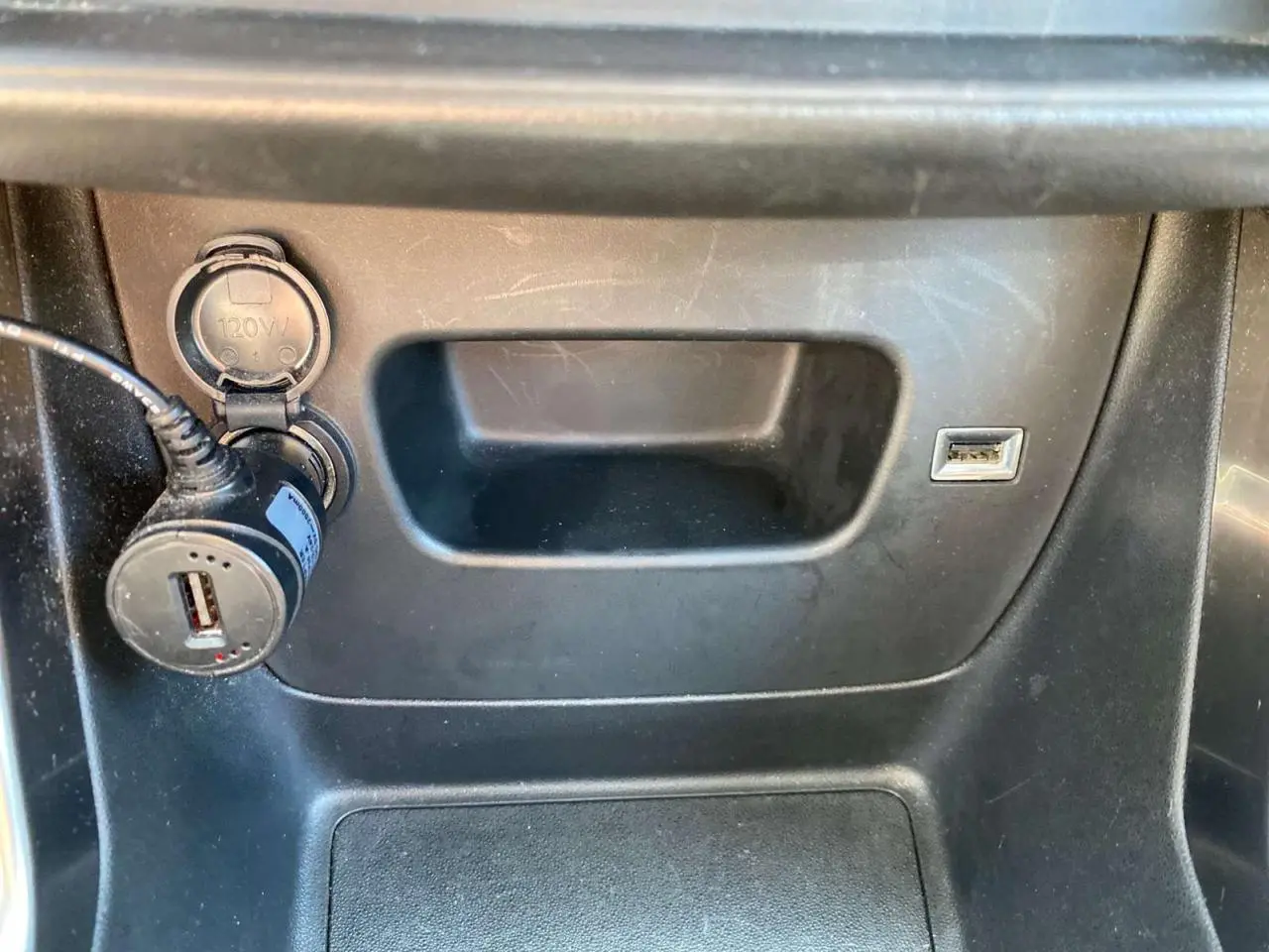 Prise USB et allume-cigare avec adaptateur dans le compartiment central d'une Citroën C3 Aircross 2023 gris Artense.