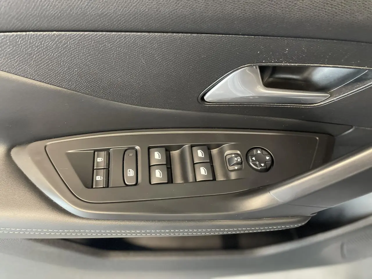 Commande des vitres et rétroviseurs sur la porte côté gauche d'une Peugeot 308 gris Artense 2022 finition Allure Pack