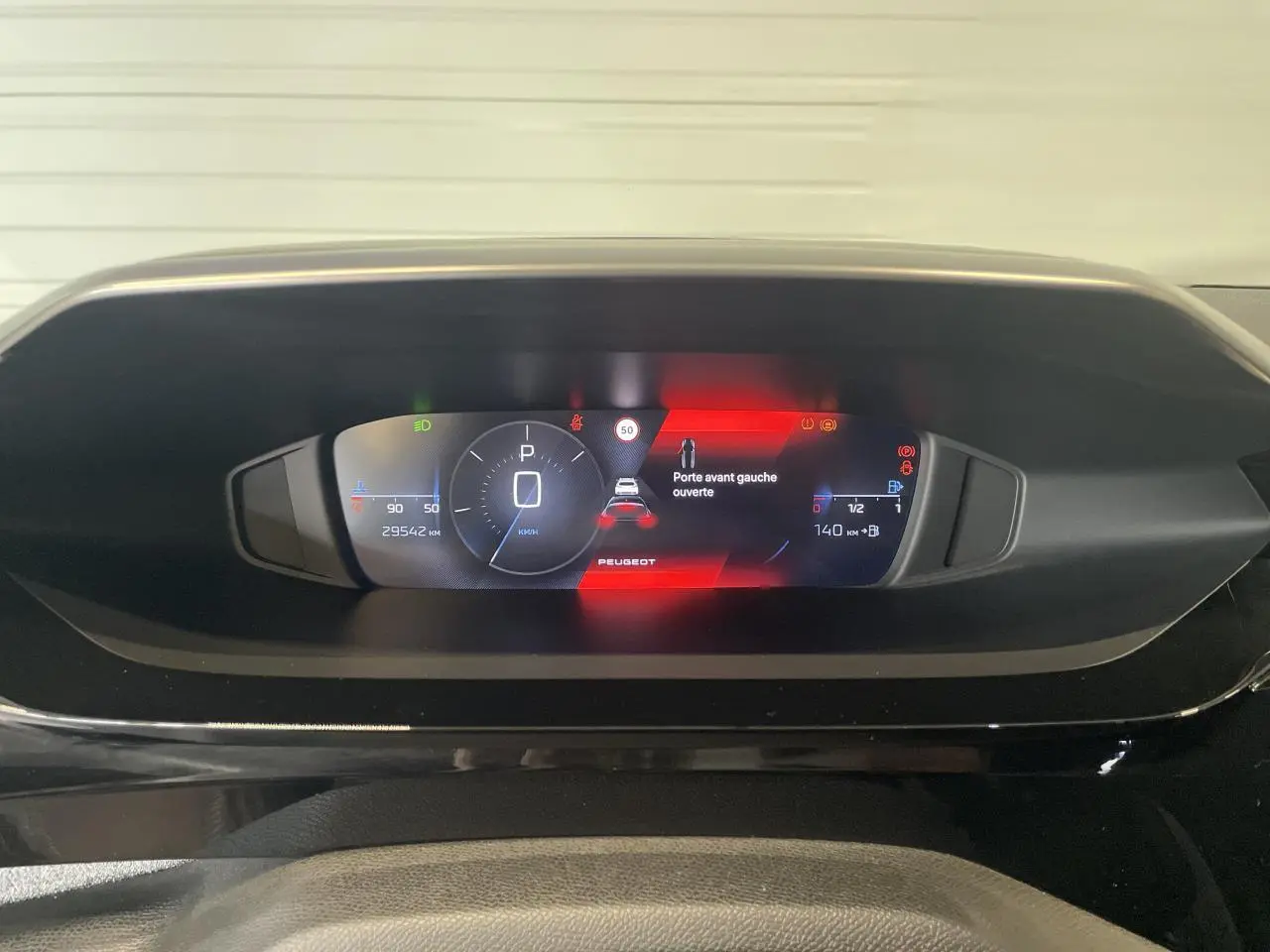 Combiné numérique du tableau de bord de la Peugeot 308 2022 affichant une alerte porte avant gauche ouverte.