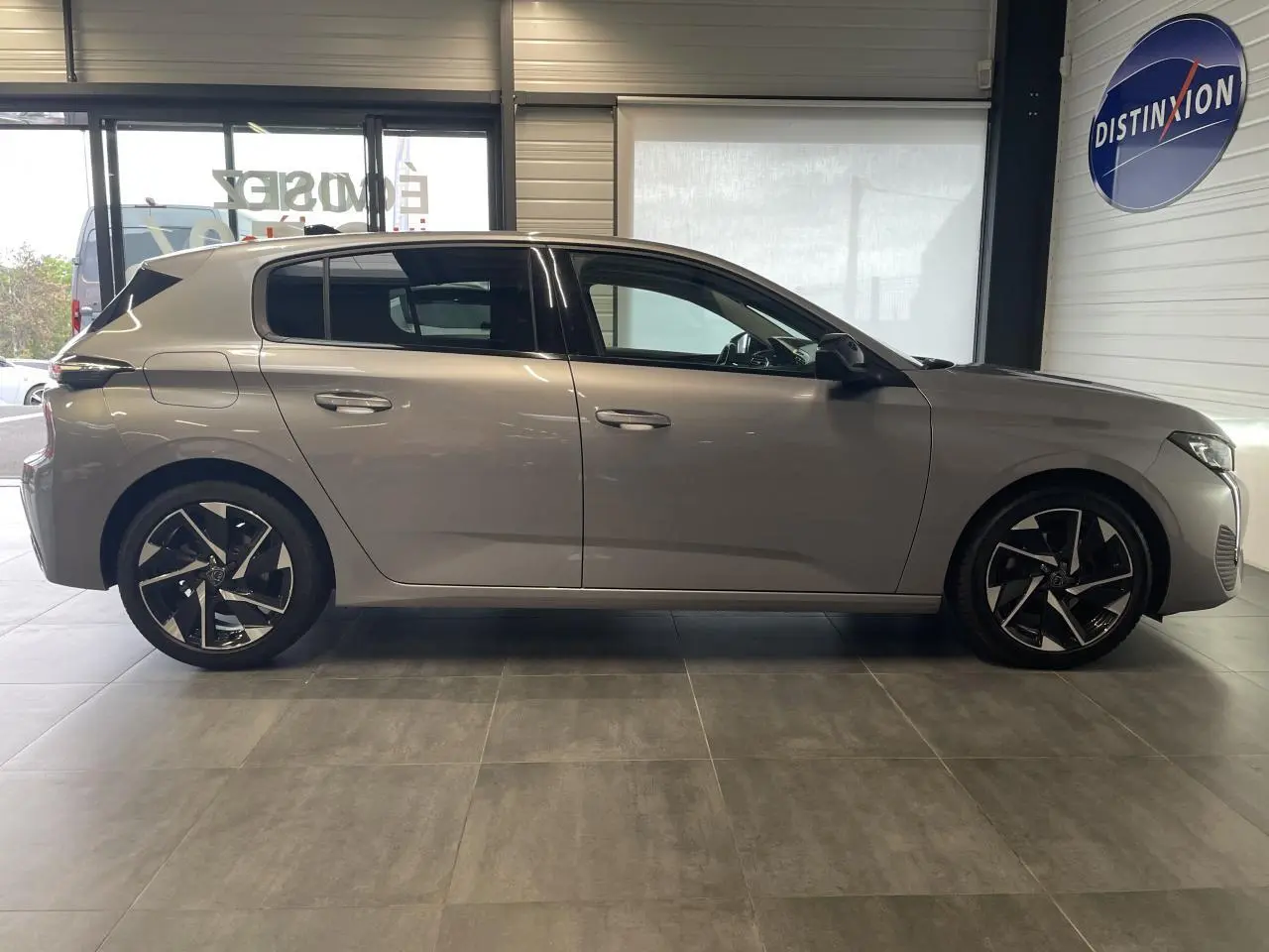 Peugeot 308 gris Artense vue de profil côté gauche, avec jantes alliage 17 pouces et poignées couleur carrosserie.