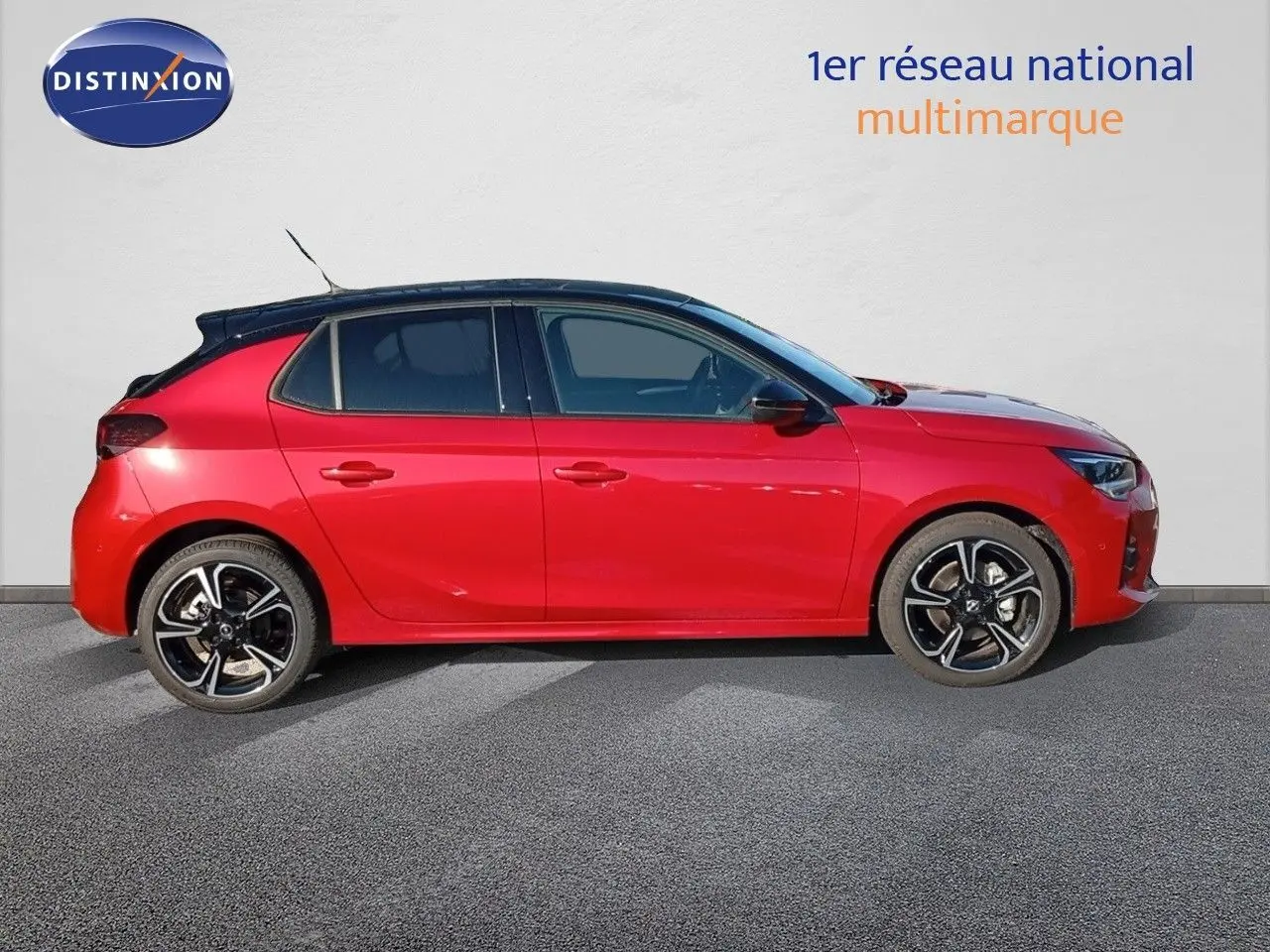 Profil gauche d'une Opel Corsa 2023 rouge Kardio métal avec toit noir et jantes alliage bicolores.