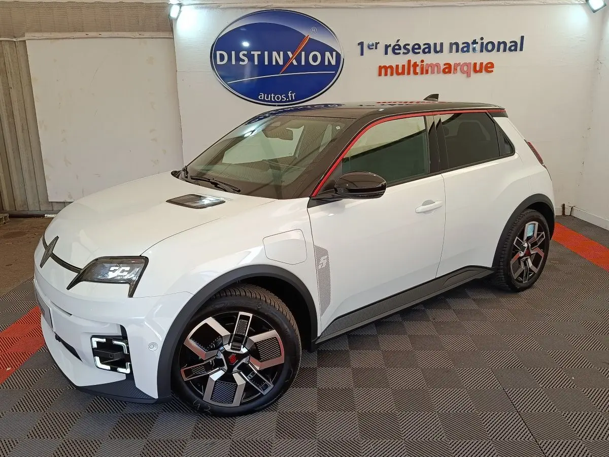 Vue 3/4 avant droit d'une Renault R5 Techno blanche avec toit noir et jantes au design moderne.