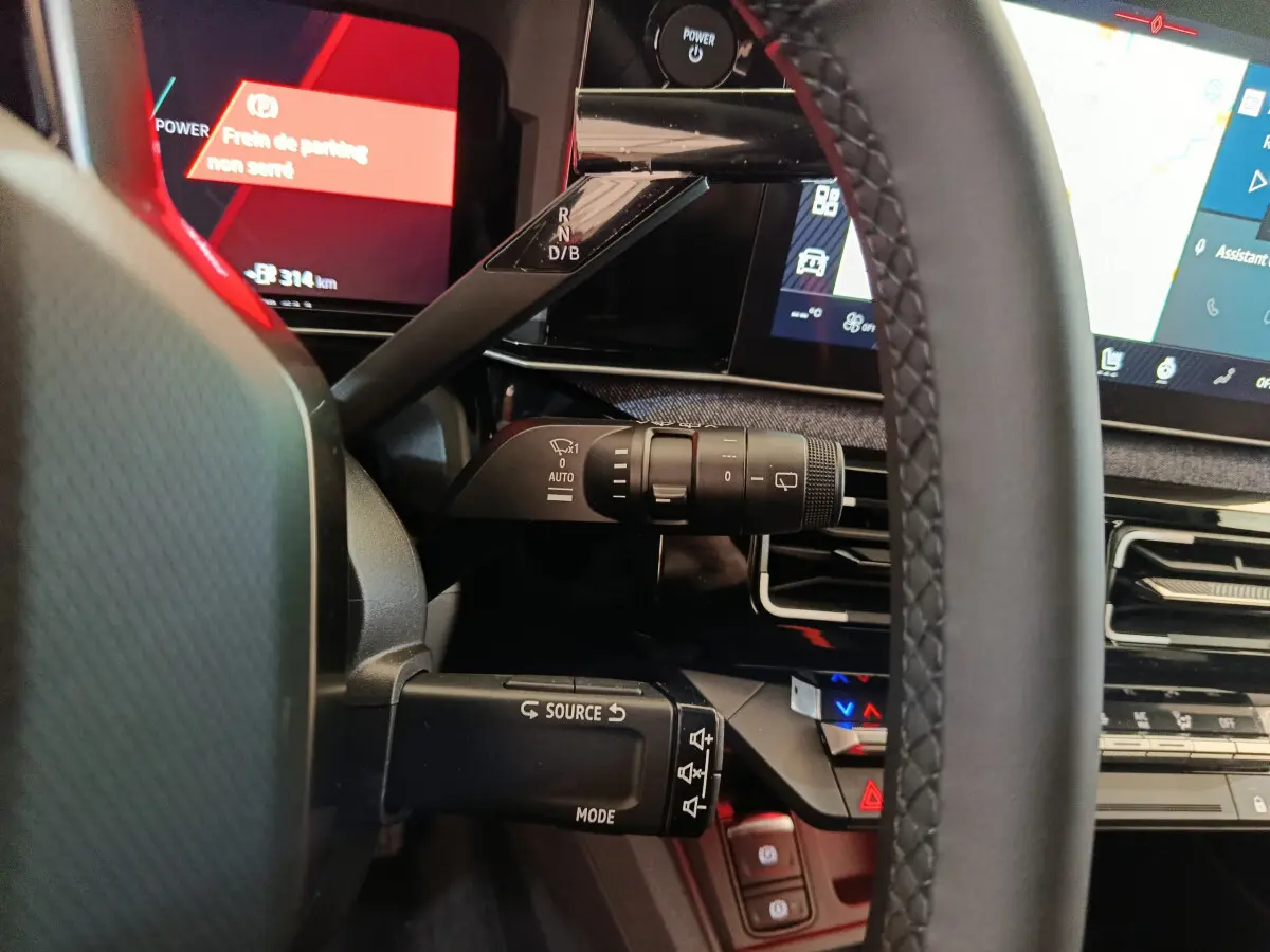 Vue rapprochée du volant et des commandes au tableau de bord de la Renault R5 Techno 150 ch blanc, affichage numérique.