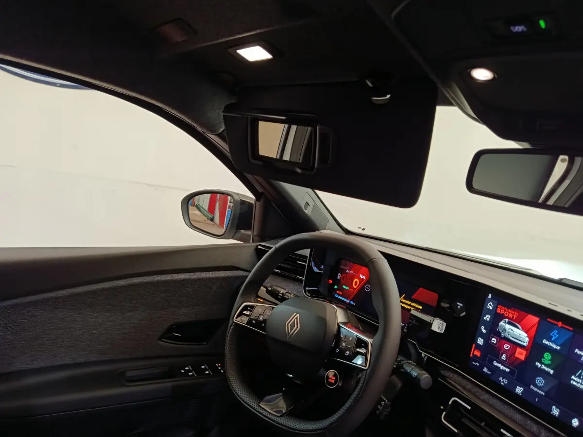Vue intérieure côté conducteur de la Renault R5 Techno 150 ch blanc, avec volant multifonctions et écran tactile large.