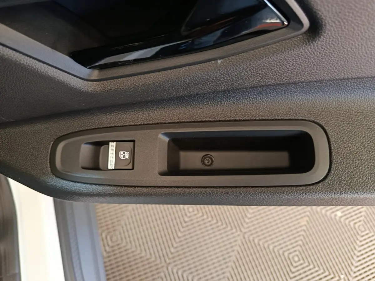 Détail de la commande de lève-vitre côté conducteur sur porte intérieure noire de Renault R5 Techno 2025 blanc.