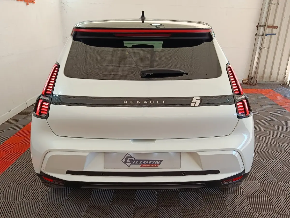 Vue arrière d'une Renault R5 Techno blanche de 2025 avec feux LED verticaux et logo Renault lumineux.