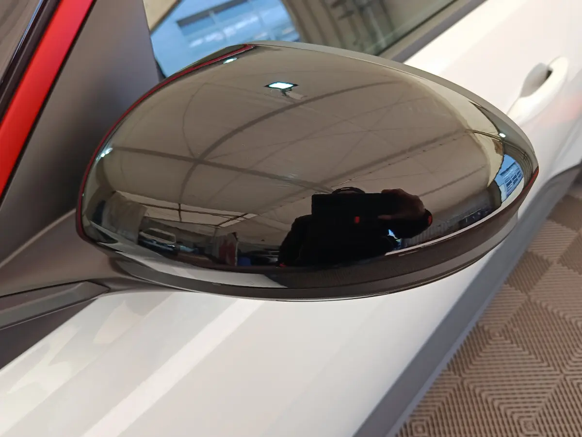 Rétroviseur extérieur droit noir brillant sur Renault R5 Techno blanc, vue rapprochée sur porte et poignée.