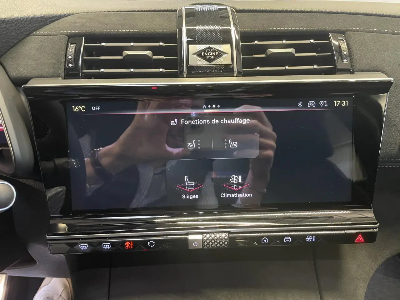 Écran tactile central du DS7 Crossback gris titanium, affichant les fonctions de chauffage, entouré d'inserts noirs brillants et Alcantara noir.