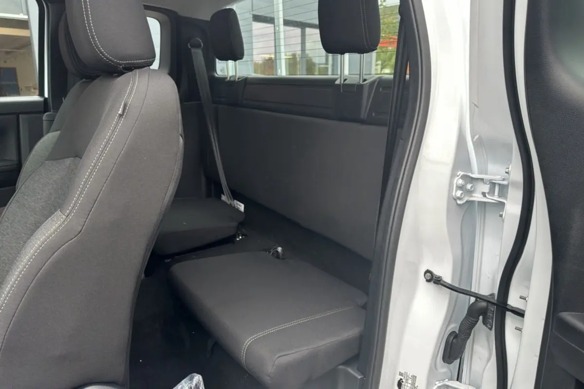Vue intérieure arrière côté droit du Ford Ranger blanc glacier Supercab, montrant les sièges arrière rabattus et l'habitacle.