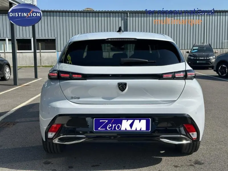 Vue arrière d'une Peugeot 308 blanche avec feux arrière LED et double sortie d'échappement chromée.