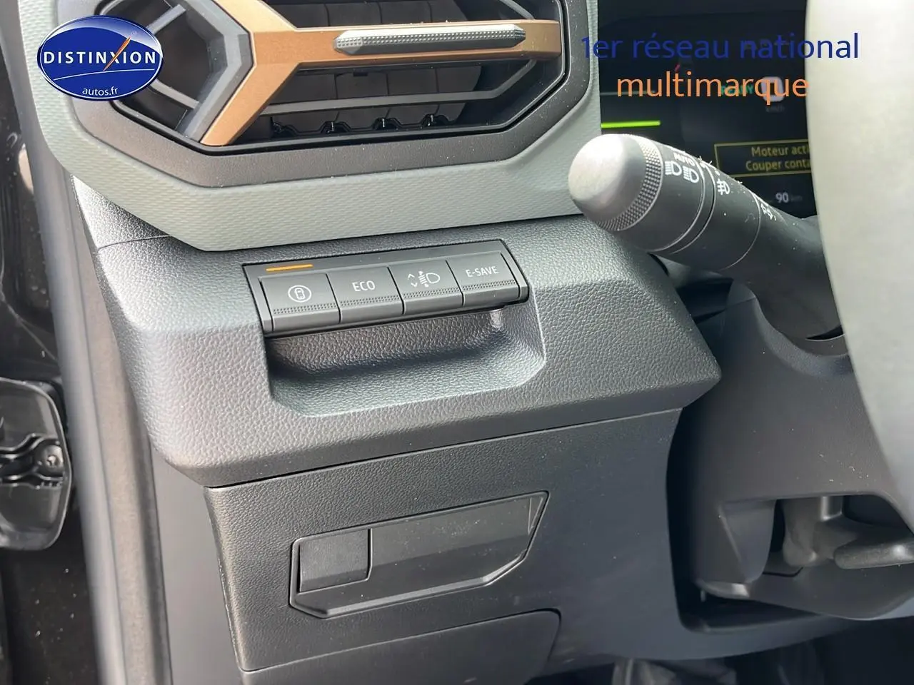Détail du tableau de bord noir du Dacia Duster 2025 avec commandes eco, e-save et régulateur de phares.