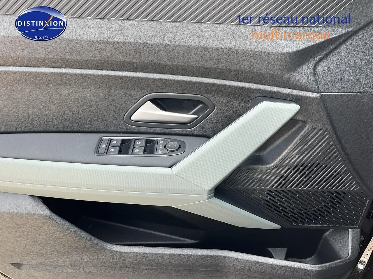 Détail de la porte avant gauche du Dacia Duster noir 2025, avec commandes des vitres et haut-parleur intégré.